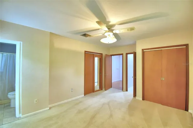 a view of an empty room with a ceiling fan