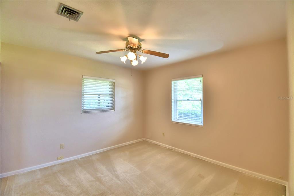1475 Lake Howard Drive Southwest Winter Haven, FL 33880 - Photo 14 of 25 an empty room with windows and fan