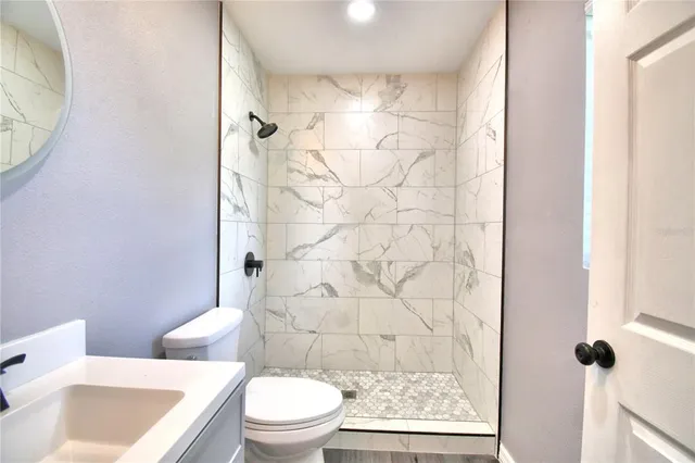 a white toilet sitting next to a bathroom sink and shower