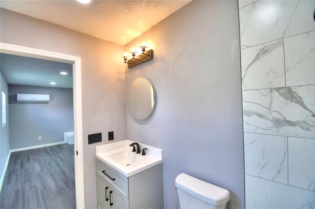 1475 Lake Howard Drive Southwest Winter Haven, FL 33880 - Photo 21 of 25 a bathroom with a toilet sink and mirror