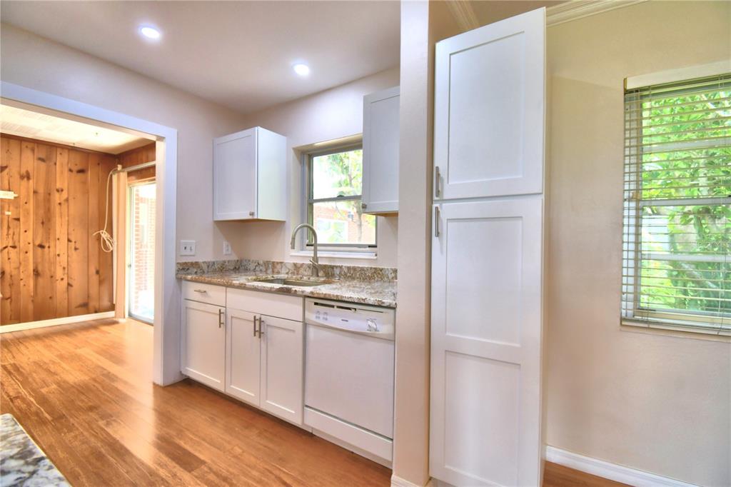 1475 Lake Howard Drive Southwest Winter Haven, FL 33880 - Photo 4 of 25 a kitchen with granite countertop white cabinets and white appliances