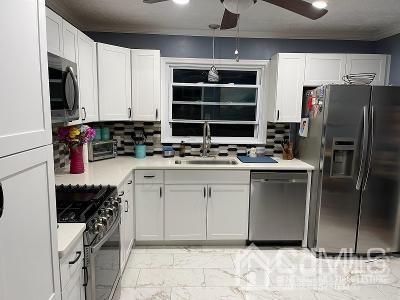 566 New Dover Road Colonia, NJ 07067 - Photo 4 of 23 a kitchen with white cabinets and appliances