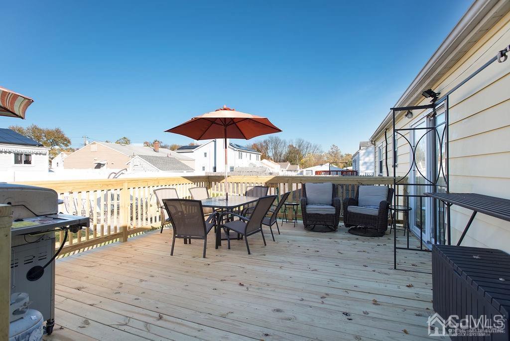 566 New Dover Road Colonia, NJ 07067 - Photo 6 of 23 a view of a roof deck with table and chairs under an umbrella with wooden floor