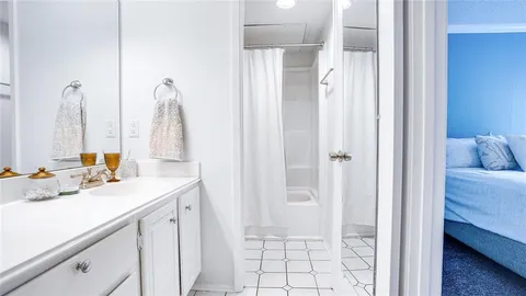 a bed sitting in a spacious bedroom next to a window