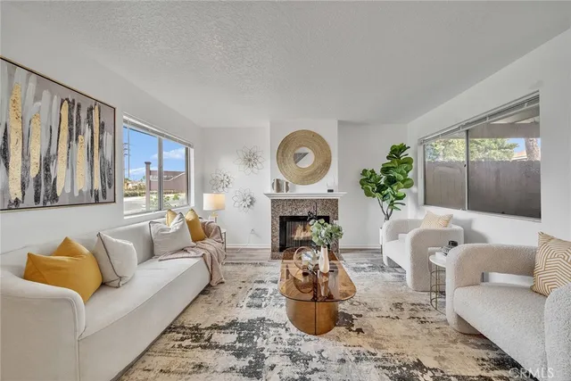 a living room with furniture a fireplace and a large window