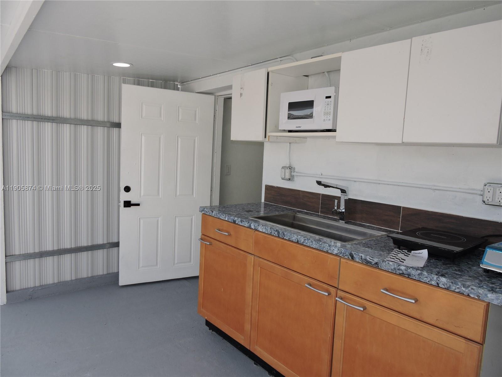5451 West 10th Avenue, Unit 5 Hialeah, FL 33012 - Photo 3 of 26 a kitchen with stainless steel appliances granite countertop white cabinets and a refrigerator