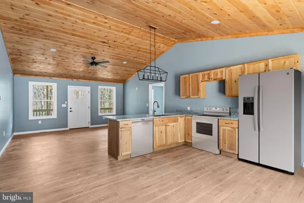 a large kitchen with stainless steel appliances granite countertop a stove and a refrigerator
