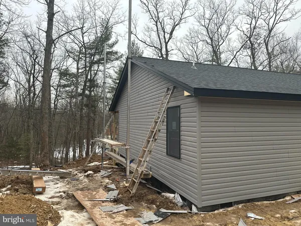 a backyard of a house with large trees and wooden fence