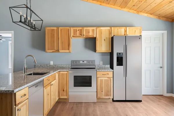 a kitchen with stainless steel appliances a stove a sink and a refrigerator
