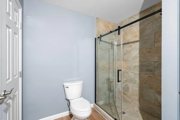 a bathroom with a toilet and a shower