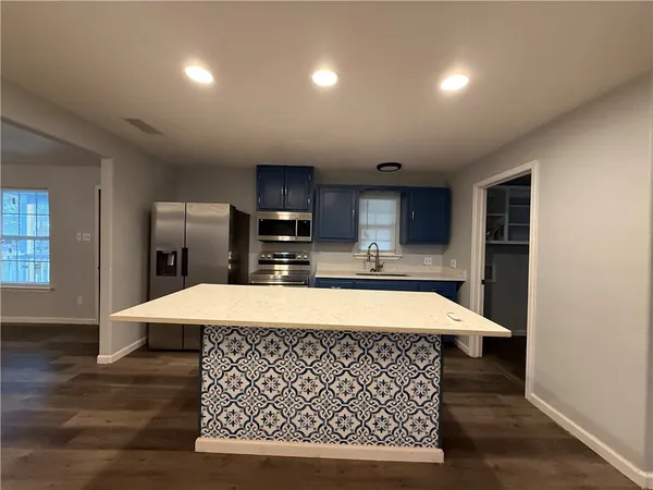 a room with kitchen island a wooden floor and a window