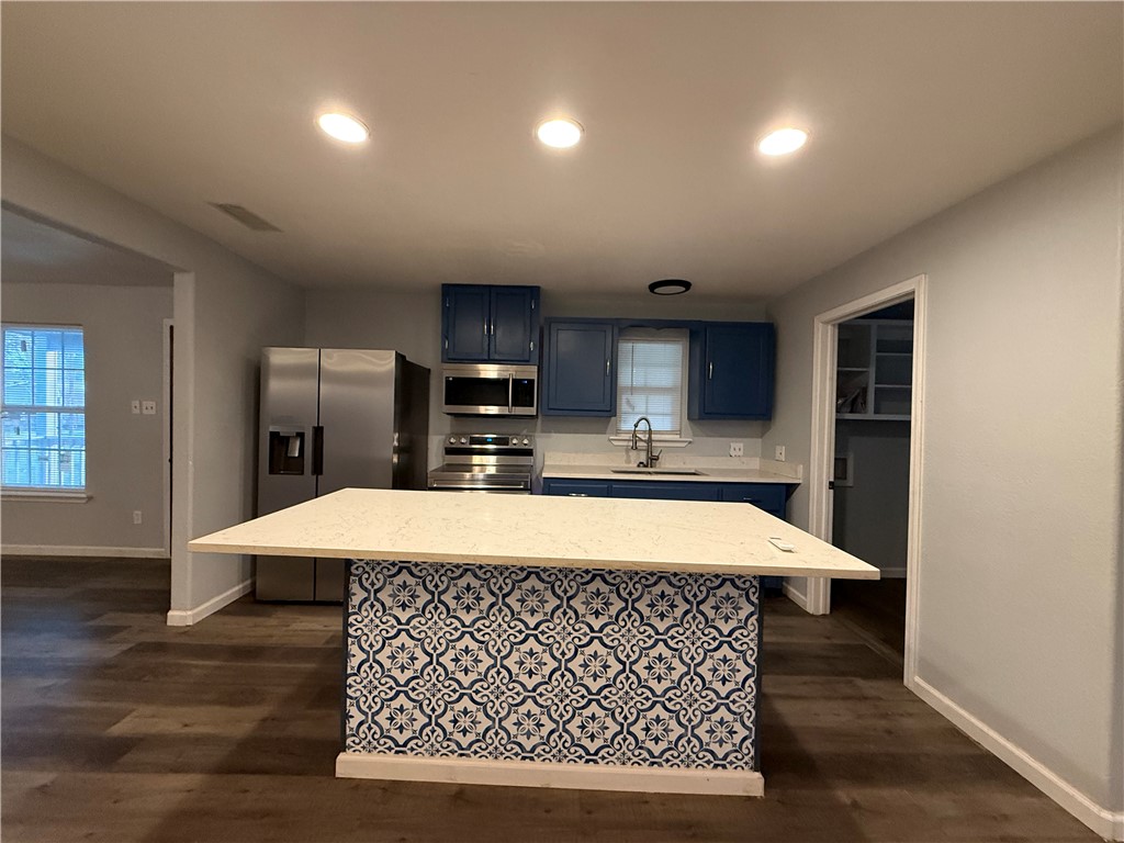 917 Corazan Street Alice, TX 78332 - Photo 12 of 37 a room with kitchen island a wooden floor and a window