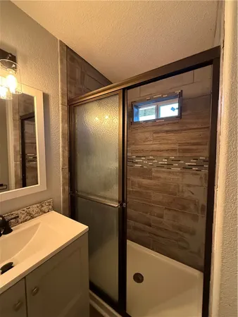 a bathroom with a sink a shower and mirror