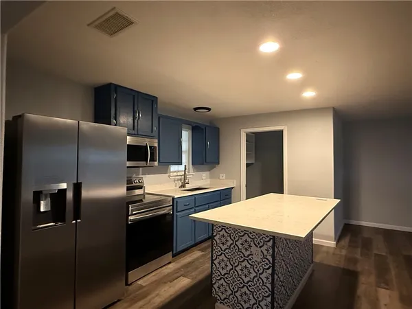 a kitchen with stainless steel appliances a refrigerator sink and stove