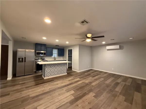 a view of kitchen with refrigerator cabinets and wooden floor