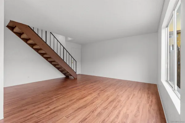a view of a hallway with wooden floor and staircase