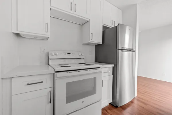 a kitchen with stainless steel appliances white cabinets and a refrigerator