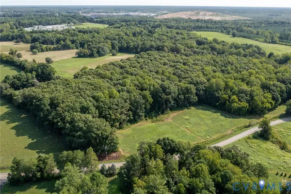 an aerial view of a residential houses with outdoor space and trees