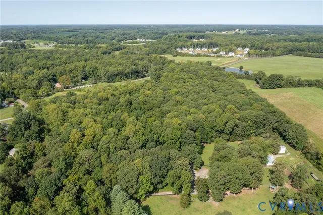 an aerial view of residential houses with outdoor space and trees