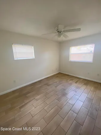 an empty room with a ceiling fan and window