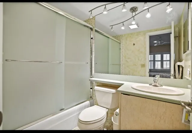 a bathroom with a toilet sink and mirror