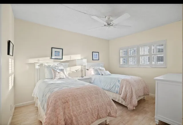 a bedroom with two large bed and a window