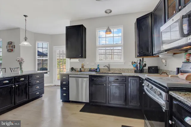 a kitchen with stainless steel appliances granite countertop a stove sink and cabinets