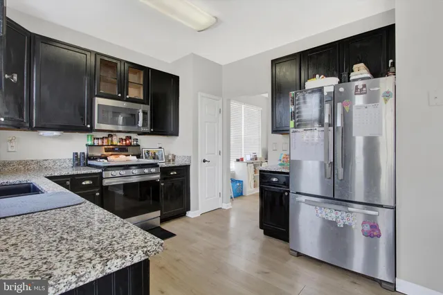 a kitchen with stainless steel appliances a sink cabinets and a refrigerator
