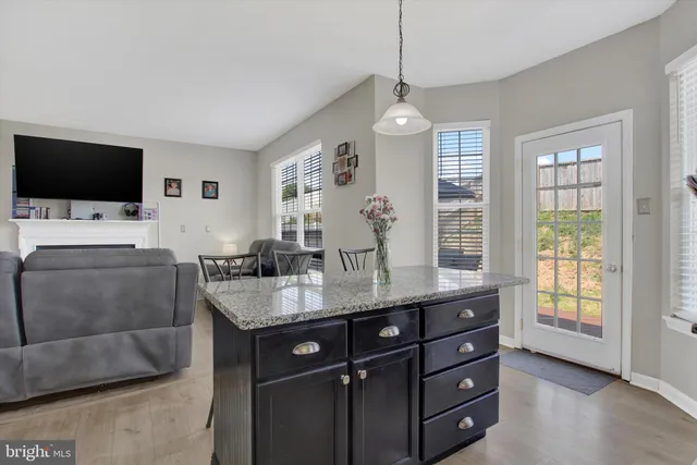 a kitchen with a dining table chairs and refrigerator