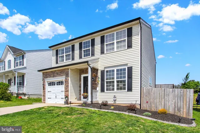 a front view of a house with a garden and plants