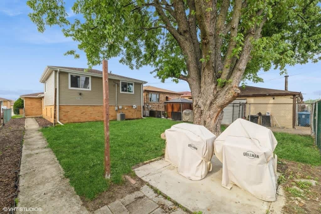 1119 Harding Avenue Calumet City, IL 60409 - Photo 10 of 11 a front view of a house with a garden and trees