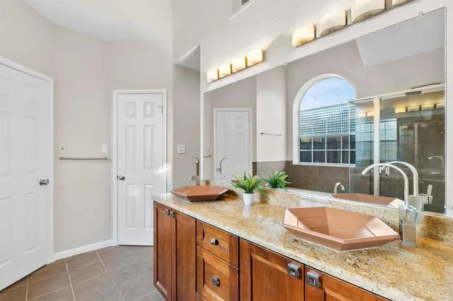a bathroom with a granite countertop sink a mirror and shower