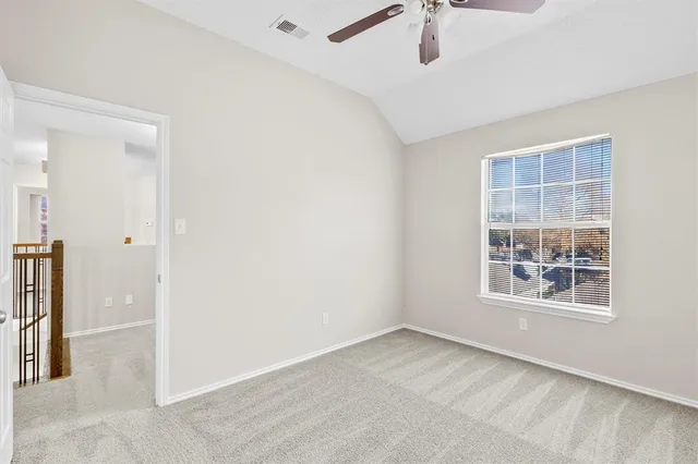 an empty room with windows and ceiling fan