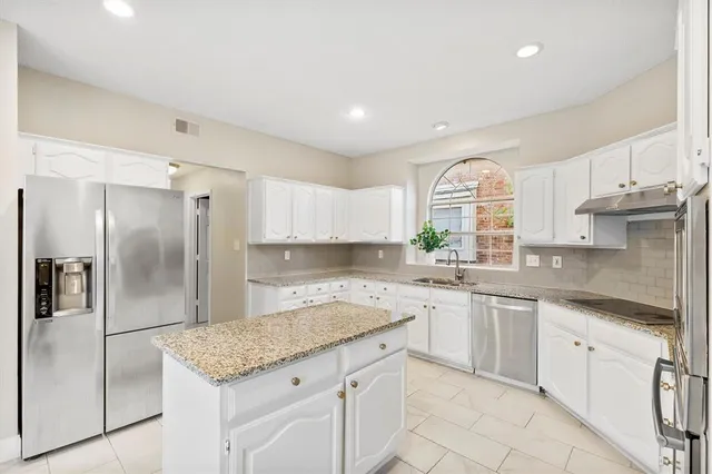 a kitchen with white cabinets appliances and a sink