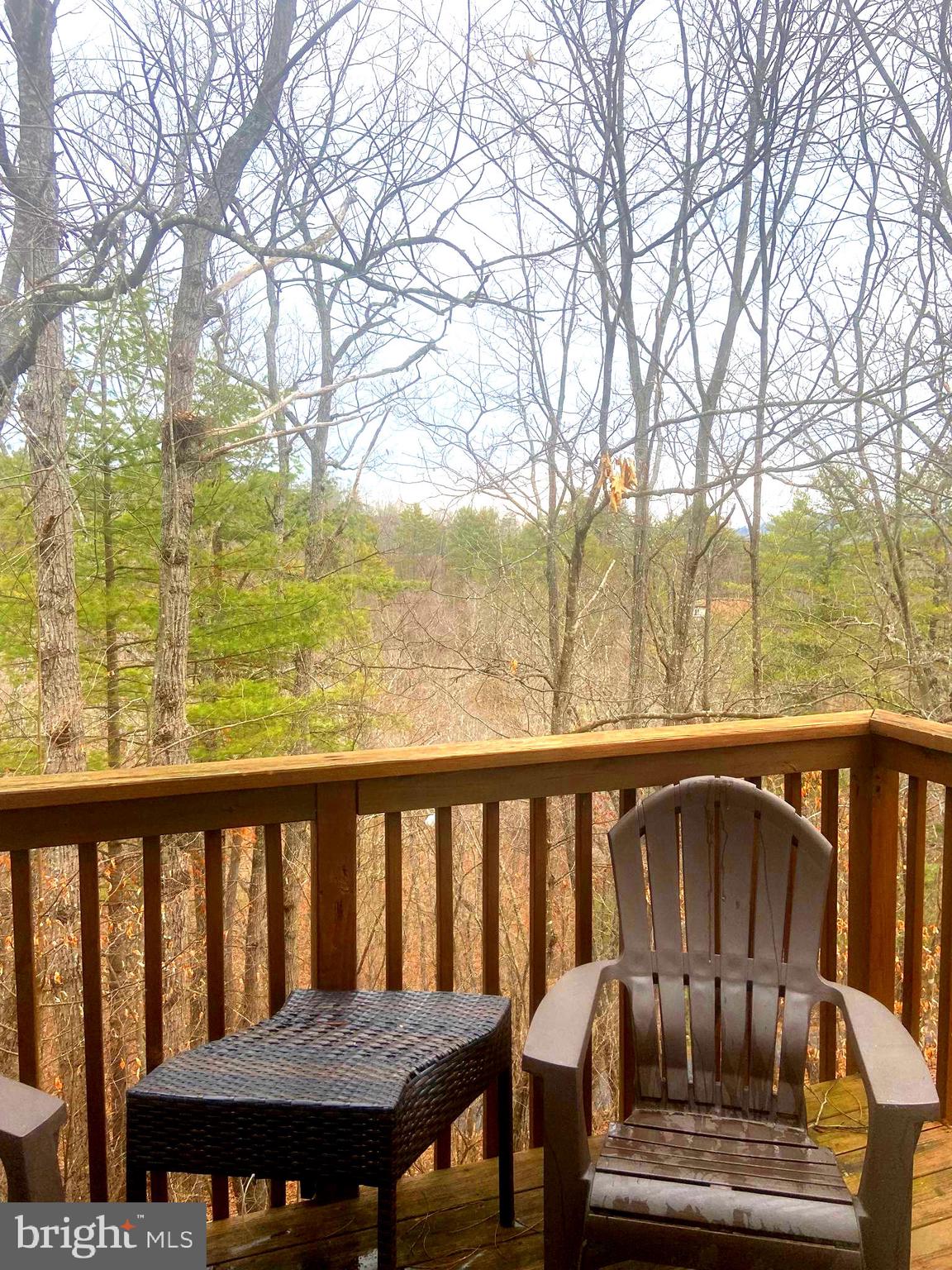 529 King Street Basye, VA 22810 - Photo 4 of 32 a view of a balcony with wooden chairs and wooden fence