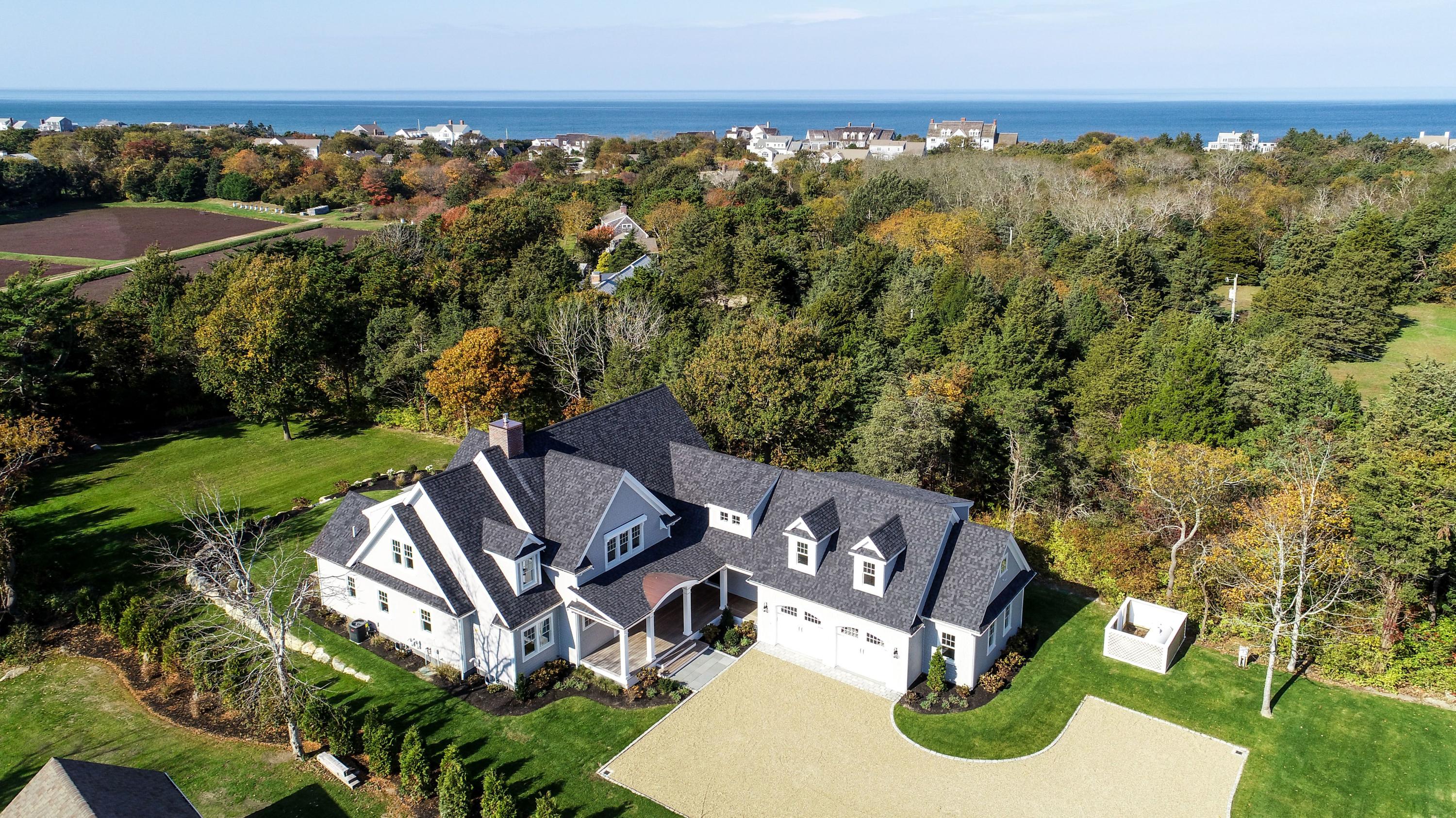 an aerial view of a house with a garden and lake view