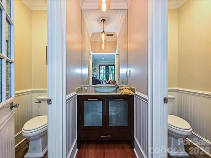 a bathroom with a granite countertop toilet a sink and a mirror