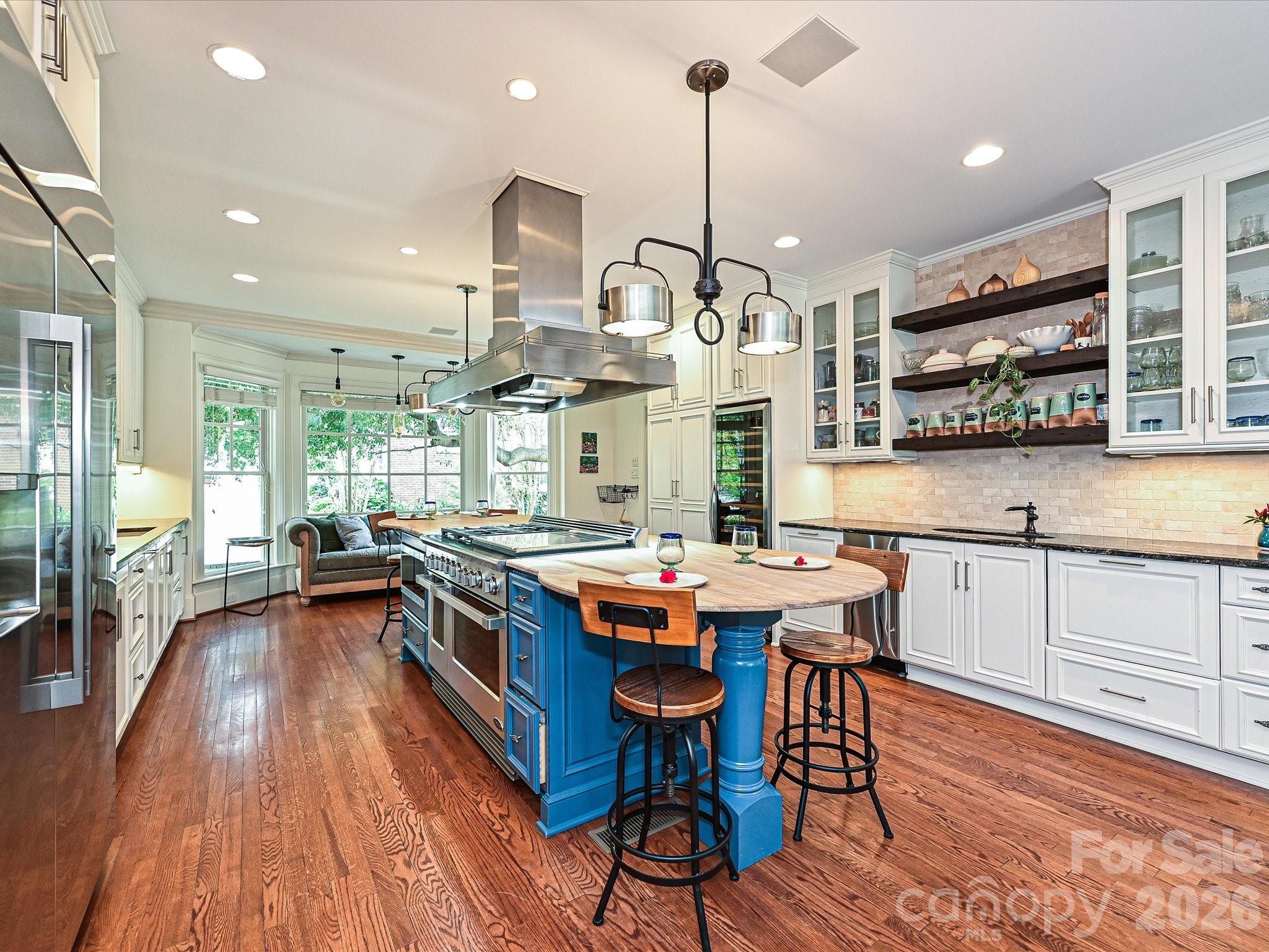 2132 Rolston Drive Charlotte, NC 28207 - Photo 5 of 41 a kitchen with stainless steel appliances a stove center island wooden floor and a window