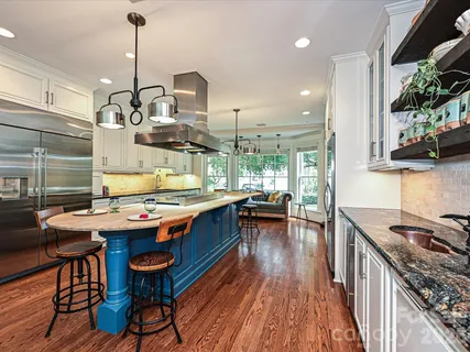 a kitchen with stainless steel appliances granite countertop a stove a sink dishwasher and a dining table with garden view