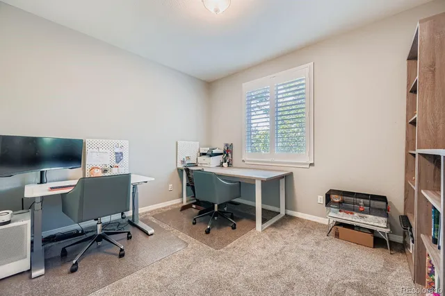 a view of a workspace with furniture and a window