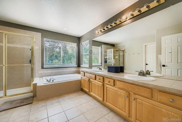 a spacious bathroom with a granite countertop tub sink and mirror