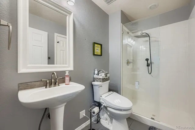 a bathroom with a sink a toilet and shower
