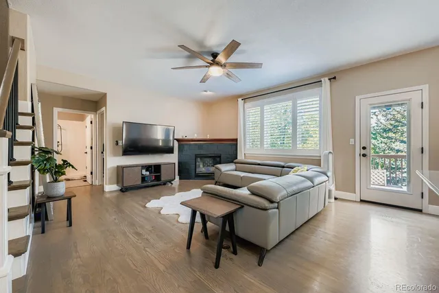 a living room with furniture a flat screen tv and a large window
