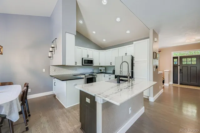 a kitchen with a sink stainless steel appliances and white cabinets