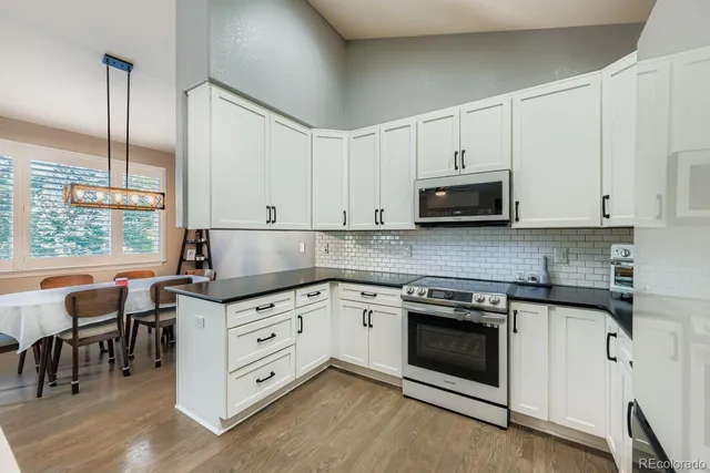 a kitchen with granite countertop white cabinets and white appliances