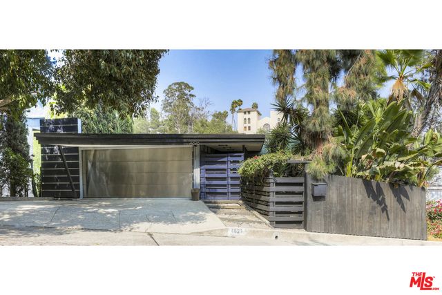 a front view of a house with a tree