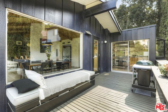 a view of a patio with a dining table and chairs with wooden floor and fence