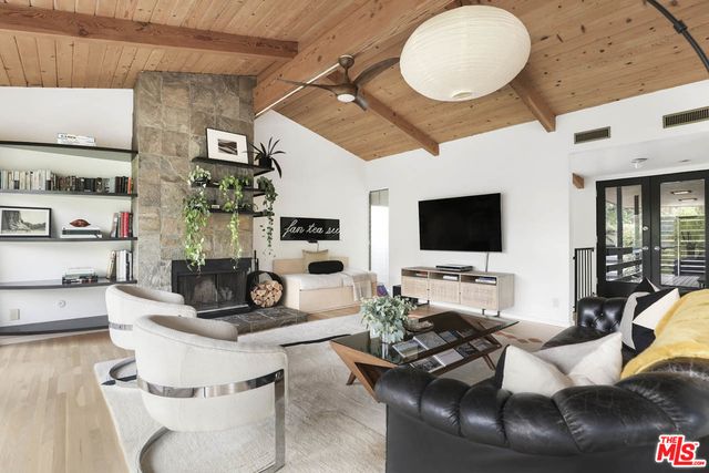 a living room with furniture a flat screen tv and kitchen view