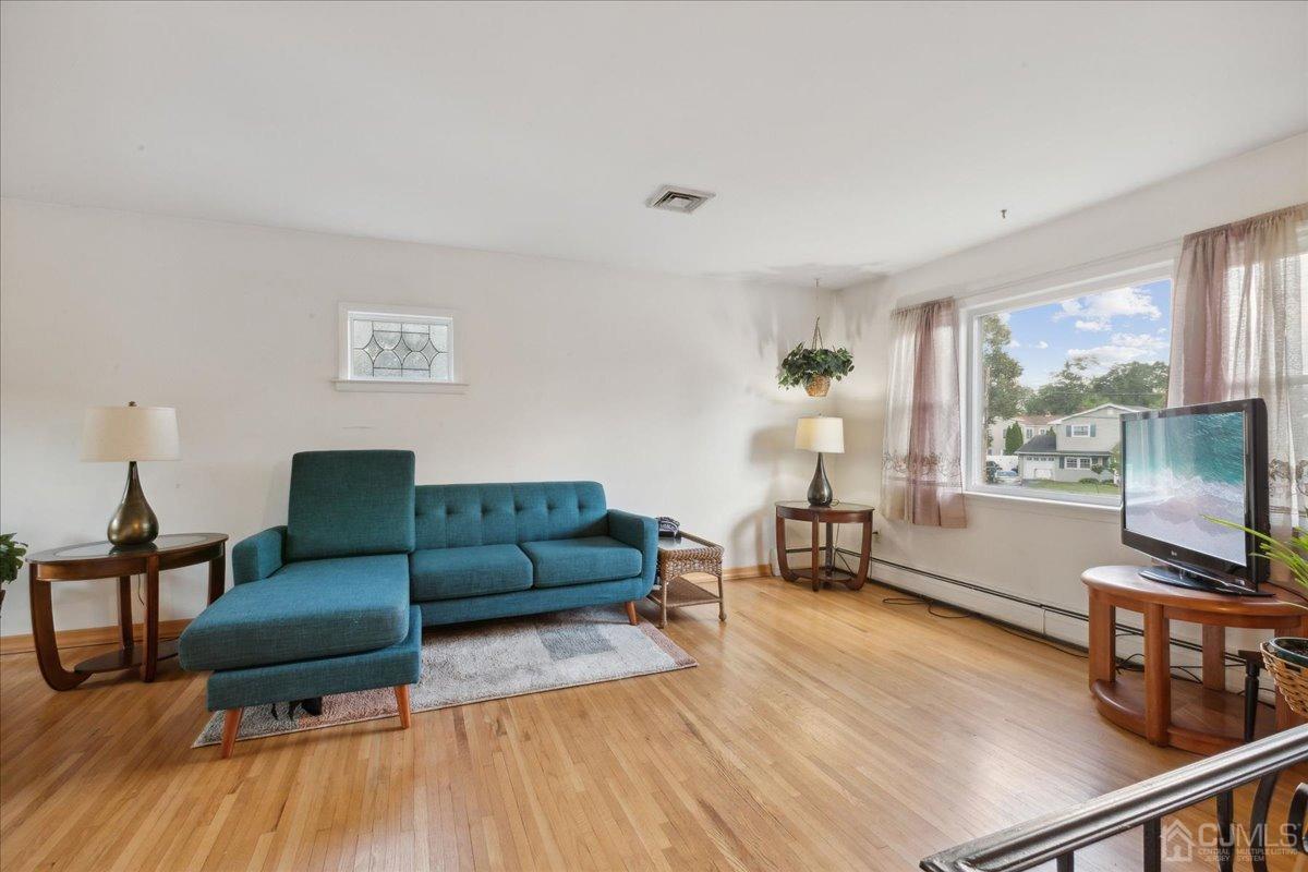 15 Weiss Drive Middlesex, NJ 08846 - Photo 5 of 33 a living room with furniture and a flat screen tv with wooden floor