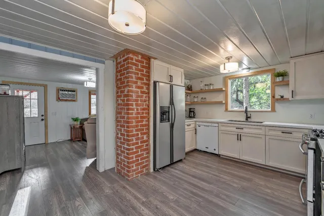a kitchen with white cabinets and window